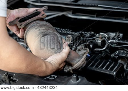 Close Up Old Catalytic Converter In Hand Technician Remove From Engine Gasoline Car Dust Clogged Con