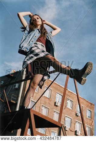 Beautiful Grunge (rock) Girl Takes A Step Down The Stairs. Informal Model Dressed In Jean Jacket, Ch