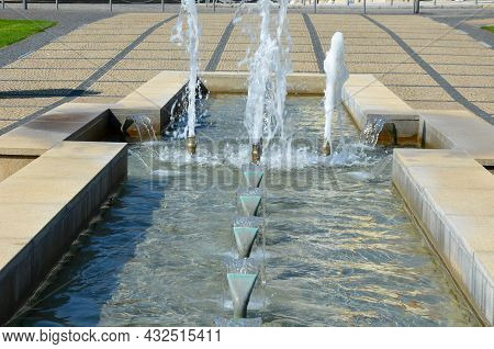 Swimming Pool With Fountains In The Shape Of An Opposite Cross On The Promenade In The Park On The S