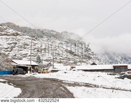 Chemal, Altai Republic, Russia - 15 October 2020: Russian Rural Village Chemal In The Snow. Wooden H