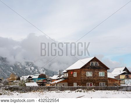 Chemal, Altai Republic, Russia - 15 October 2020: Russian Rural Village Chemal In The Snow. Wooden H