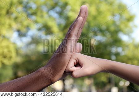 African American Man Stopping Woman's Fist Outdoors, Closeup. Antiracism Concept