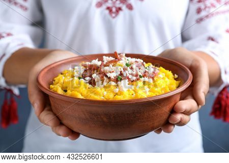 Woman Holding Bowl Of Banosh With Brynza And Pork Cracklings, Closeup. Traditional Ukrainian Dish