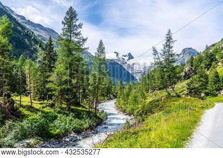 Idyllic Alpine Landscape With Grossvenediger Mountain. Small Mountain Creek In Gschloess Valley. Hoh