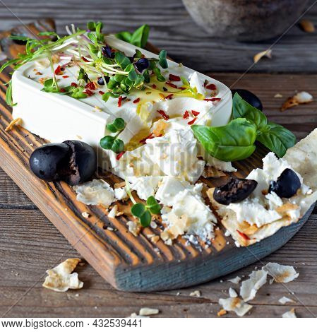 A Piece Of Fresh Feta Cheese (paneer) With Olives, Herbs, Spices And Slices Of Flatbread (tortilla, 