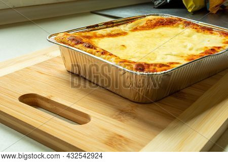 Delicious Baked Lasagne In An Aluminum Bowl On A Wooden Board