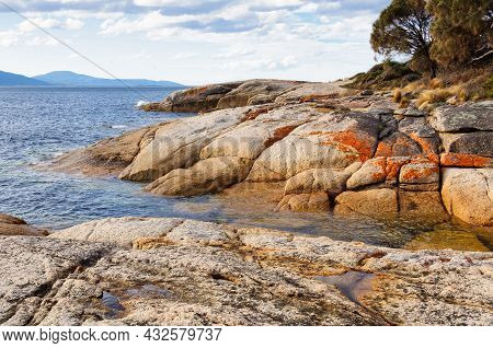 Granite Boulders Reddened By Lichens Are Polished Smooth By Waves - Swansea, Tasmania, Australia