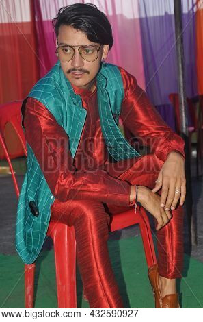 A Good Looking Indian Young Guy Posing With Sitting On Chair With Wearing Kurta, Pajama, Nehru Coat 