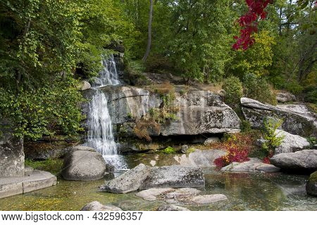 Autumn Landscape Forest Stone Mountain Waterfall And Lake. A Picturesque Cascade Waterfall Among Lar
