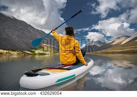 Stylish Girl In Yellow Hoodie Walks On Sup Board At The White Mountain Lake. Supboarding Concept