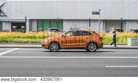 Orange Audi Q3 In Motion On Highway With Blurred Background. Moscow, Russia - July 2021