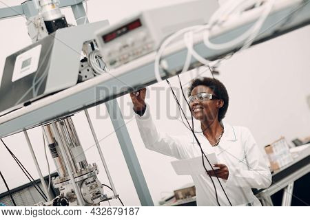 Scientist African American Woman Working In Laboratory With Electronic Tech Single Photon Detector. 