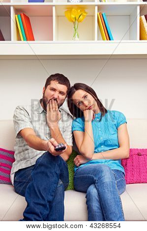 gelangweilt paar auf dem Sofa sitzen und Fernsehen