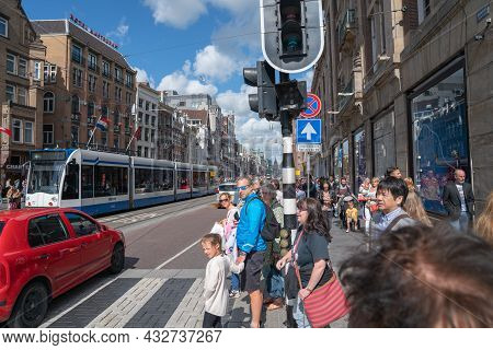Amsterdam Netherlands - August 20 2017; Busy Sidewalk In City With Group Waiting To Cross While Red 