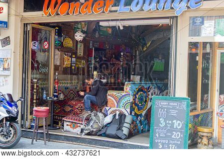 Amsterdam-netherlands - August 21 2017; Man Sits Checking His Mobile In Entrance To Quirkyvividly Co