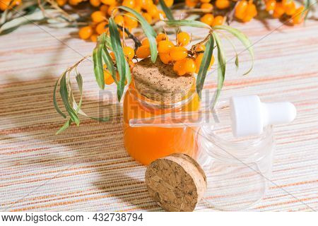 Hippophae Sea Buckthorn Cosmetic Oil In A Glass Bottle With A Pipette On A Background With Copy Spac