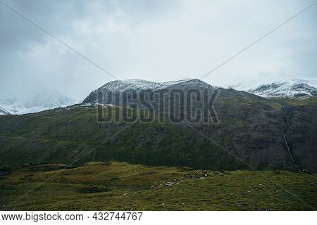 Minimalist Alpine Landscape With Snowy Mountains In Low Cloud In Overcast Weather. Deep Gorge On Bac
