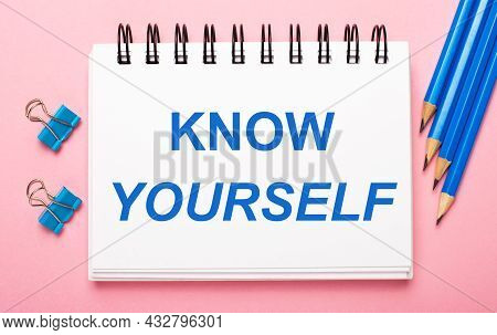 On A Light Pink Background, Light Blue Pencils, Paper Clips And A White Notebook With The Text Know 