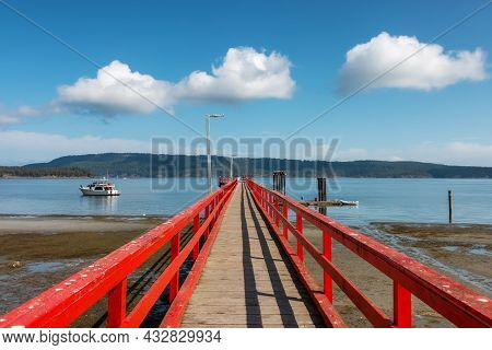 Wooden Pier By The Pacific Ocean West Coast. Sunny Summer Day. Fernwood Point Beach, Salt Spring Isl