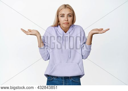 Portrait Of Confused Blond Girl, Shrugging Shoulders And Looking Clueless, Dont Know, Has Nothing To