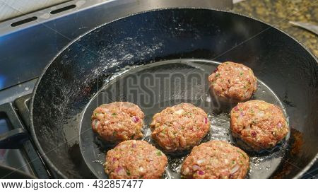 An image of some typical frikadeller in a black pan
