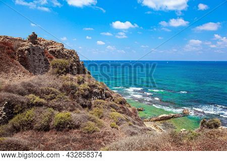 Apollonia Park, Israel. Mediterranean coast. Sea surf with white foam of waves. Picturesque ruins of the medieval citadel of Arsuf. 