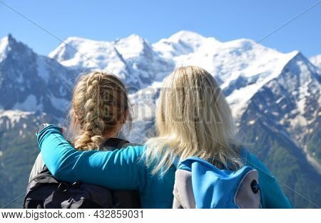 Hikers looking at the Mont Blanc from the summit of Le Brevent. French Alps, Chamonix, France.