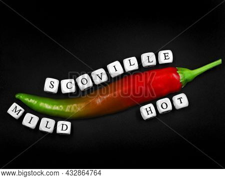 Top View Of A Chilli With Different Degrees Of Ripeness On Black Background, From Mild Green To Hot 