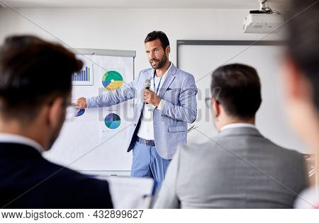 A Portrait Of A Young And Senior Smiling Businesspeople Holding A Tablet During A Meeting And Presen