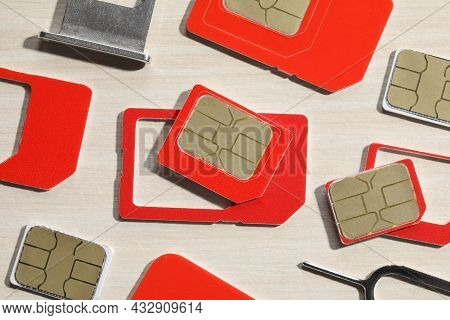 Different Sim Cards, Ejector And Tray On Wooden Background, Flat Lay