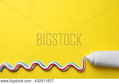 Blank Tube With Squeezed Out Toothpaste On Yellow Background, Flat Lay. Space For Text