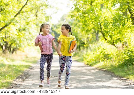 Two Happy Girls Walking And Talking Each Other In A Campus