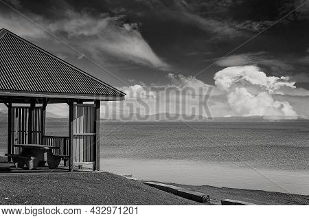 Black And White Of A Shaded Structure With Verandah Suitable For The Public To Relax At A Dam Popula