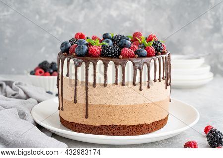 Three Chocolate Mousse Cake With Chocolate Glaze, Blueberries, Raspberries And Blackberries On Top O