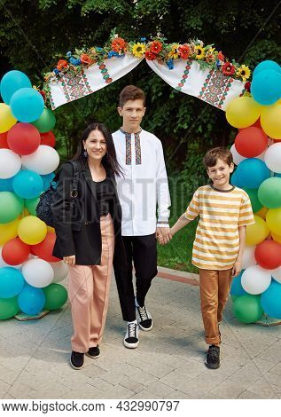 Celebration, Mother And Sons Enter The Arch Of Bouncy Balls. Multi-colored Inflatable Balls