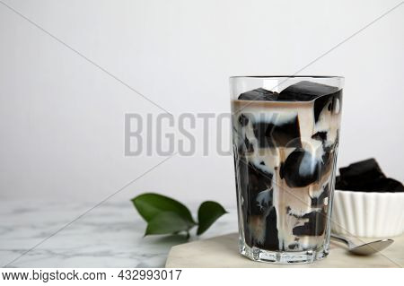Glass Of Milk With Grass Jelly On White Marble Table. Space For Text