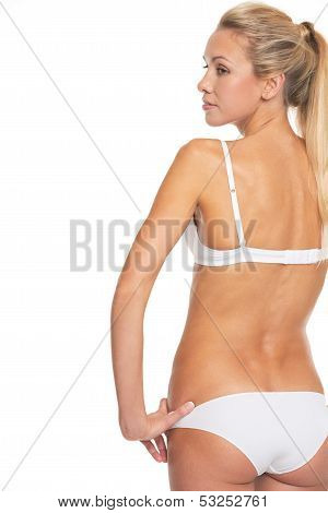 Young Woman In Lingerie Looking In Profile . Rear View