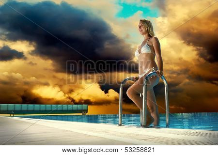 Beautiful happiness girl in white bikini stay near the waterpool