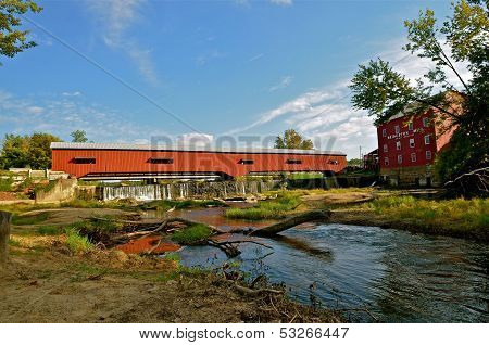 a covered bridge reflect in the water