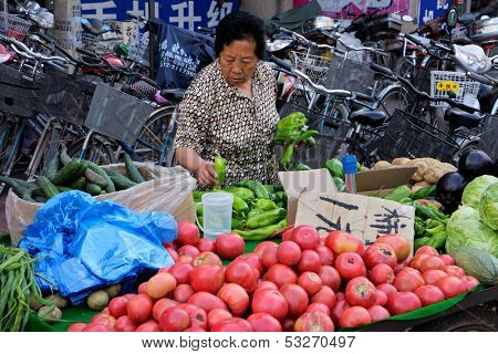 INNER MONGOLIA - JUNE 29:  Chinese woman selling her fresh produce on a street market, HoHot, Inner Mongolia, northern China, 29 June 2008. Example of the informal economic market of China.