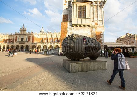 KRAKOW, POLAND - FEB 28, 2014: Igor Mitoraj's sculpture Eros Bendato (Eros Tied) 1999 on main square of the city. This worth about half a million euros bronze sculpture was donated to Krakow for free.