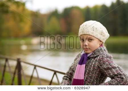 snové milá dívka v bílém baretu, stojící nedaleko břehu řeky