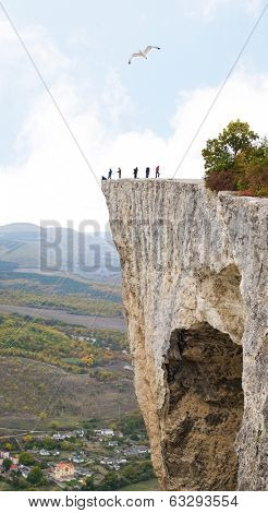 People on a steep high rock
