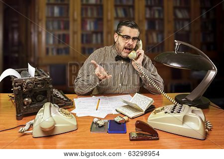 Employee with glasses talking on the phone in the office