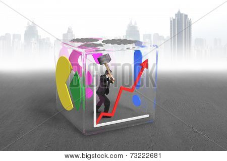 Businessman Holding Sledgehammer To Break Glass Cube