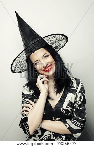Funny Witch. Young happy woman with canival hat. Studio shot.