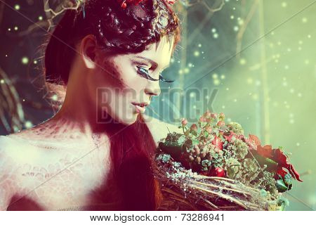 Art project. Close-up portrait of a beautiful girl in the image of a wood nymph holds winter bouquet.