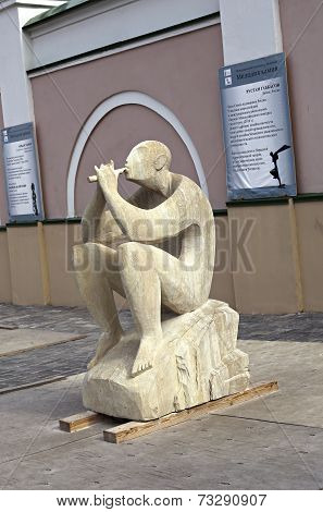 Sculpture Of A Man Playing A Flute