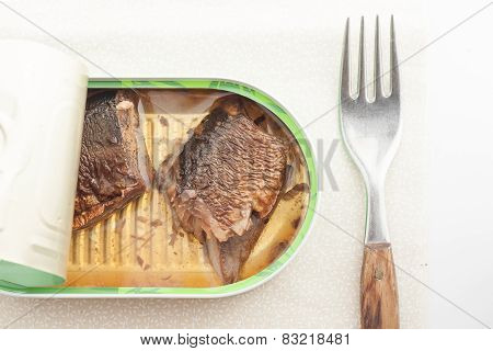 opened can of fish with a fork