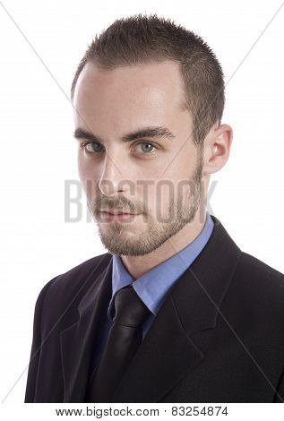 Concentrated young businessman using laptop and phone at office